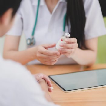 Close-up view of young female doctor explaining medical description to her patient